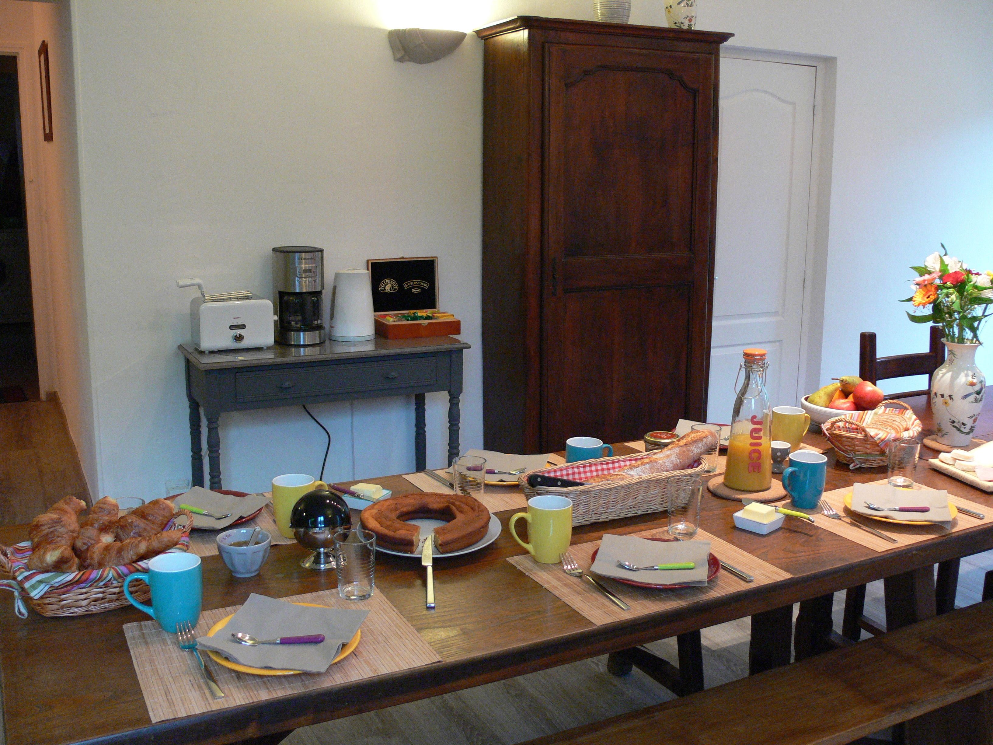 Una tavola apparecchiata con diversi cibi per la colazione, tra cui pane, pasticcini e bevande.