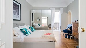 Un dormitorio con cama, cómoda, silla y espejo.