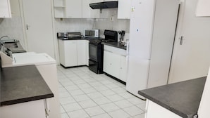 A kitchen with white cabinets, a stove, a microwave, and a refrigerator. - Addo Park View - Sundaze Riverside (Colchester)