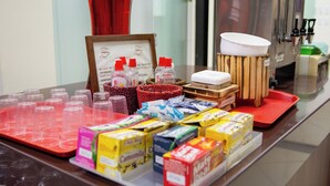A breakfast bar with various food items and disposable cups.