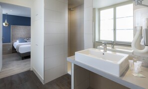 Ein modernes Badezimmer mit einem großen Waschbecken, einer Dusche und einem Spiegel.