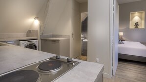 Une cuisine moderne équipée d’un lave-linge encastré, d’une cuisinière et d’un plan de travail.