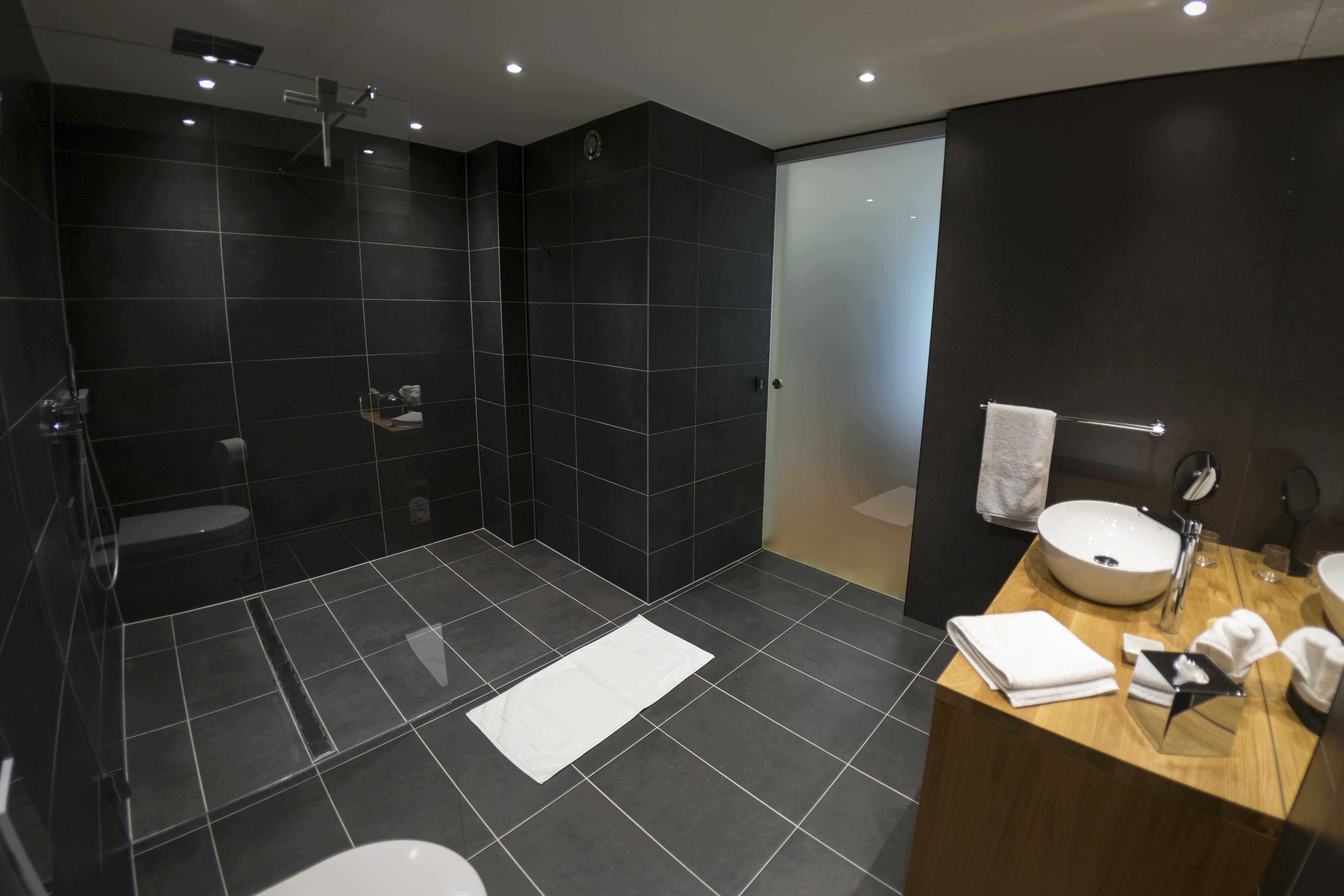 Un bagno moderno con una vasca da bagno ampia, una zona doccia separata, un mobile lavabo con lavandino e uno specchio.
