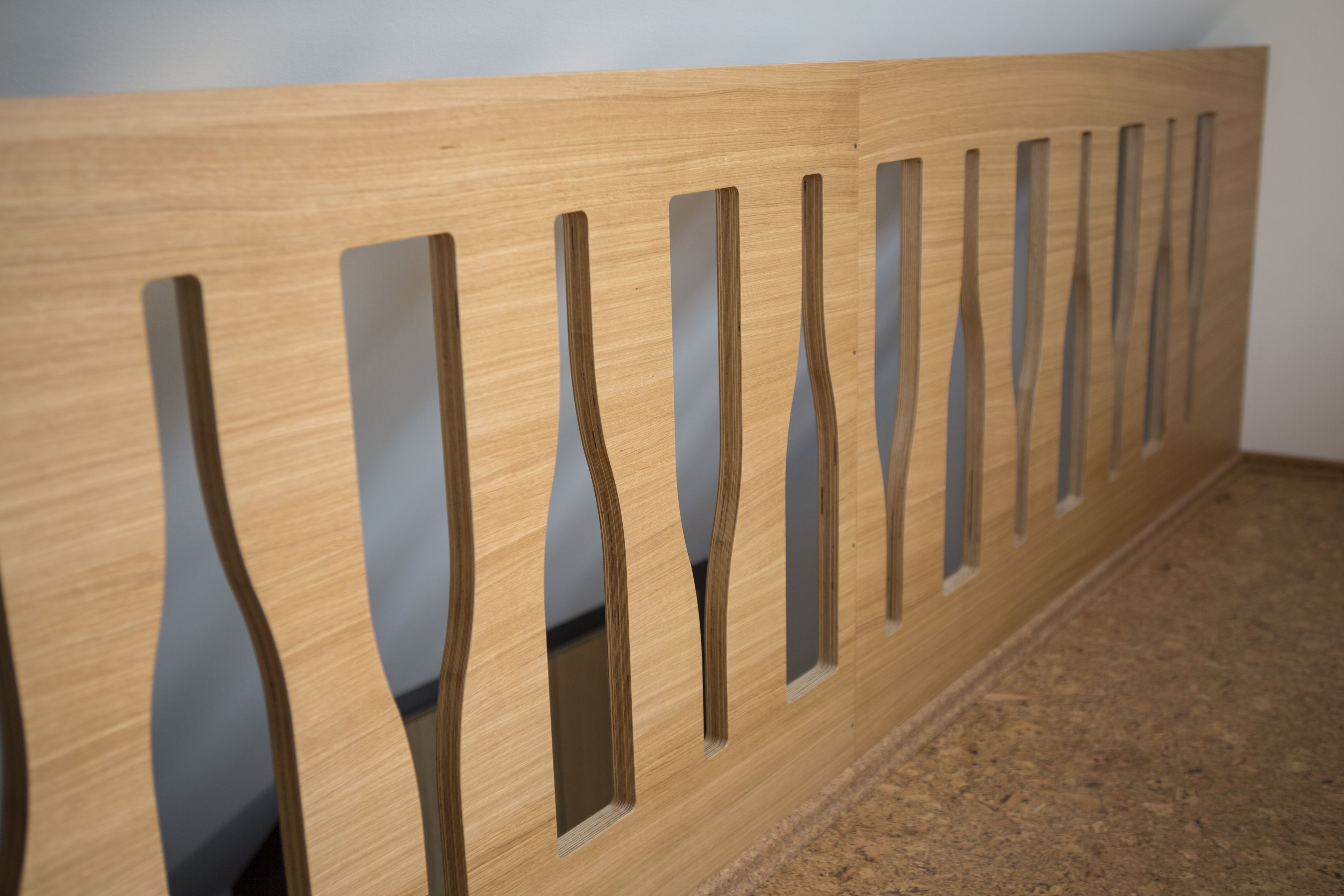 A wooden bench with a unique design featuring vertical slats and rectangular cutouts.