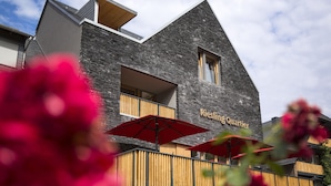 Ein modernes Gebäude mit Sandsteinfassade und der Aufschrift 'Riesling Quartier'.