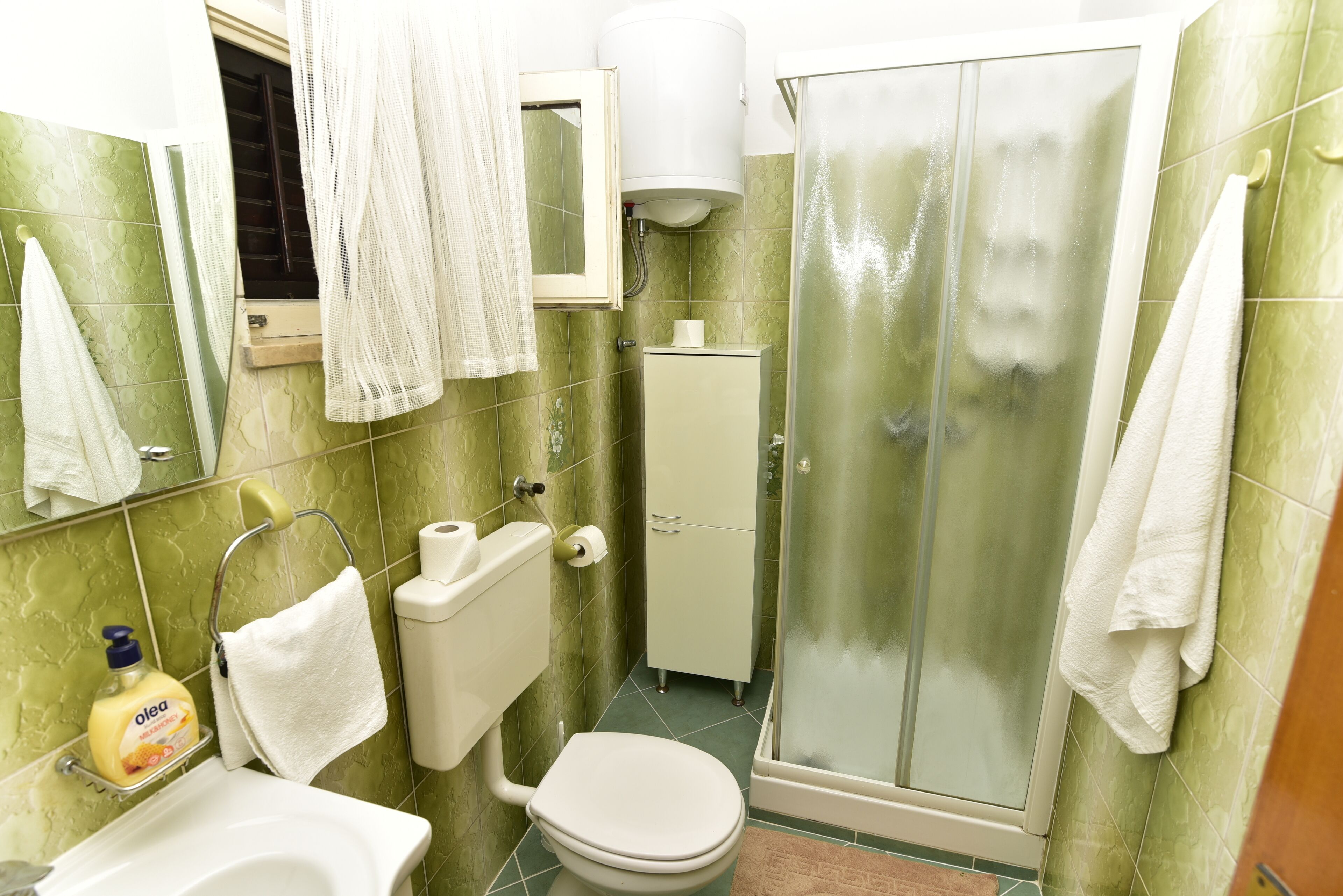 Ein Badezimmer mit Toilette, Waschbecken und Dusche.