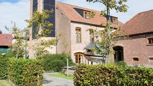 A traditional brick building with a sloped roof, a central chimney, and a small window. - Hostellerie de Biek (Aalst)
