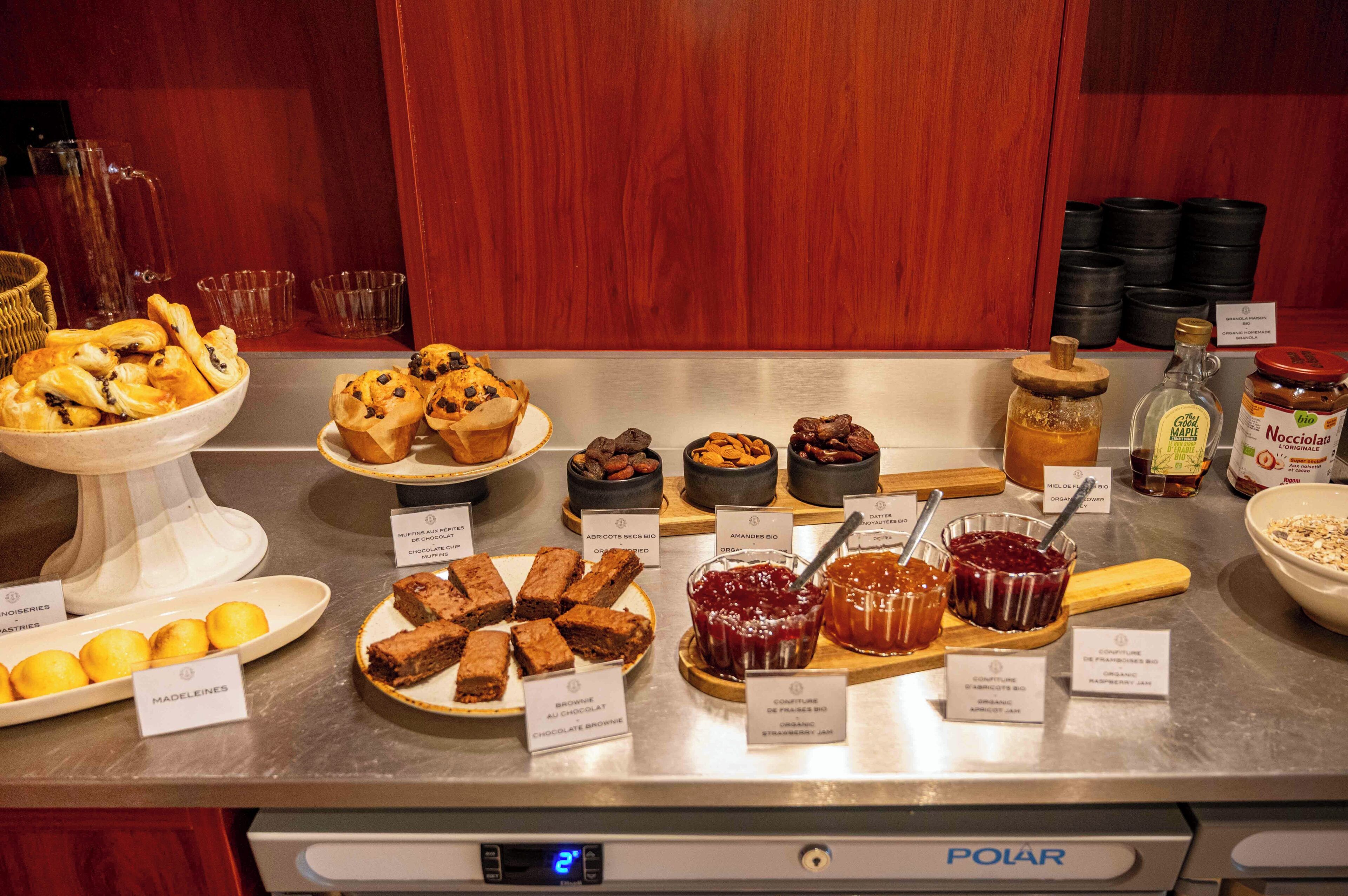 Un buffet con diversi dolci e marmellate, tra cui brownies, fette di limone e dolci al cioccolato.