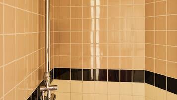 A shower with a handheld showerhead and a wall-mounted rain showerhead.