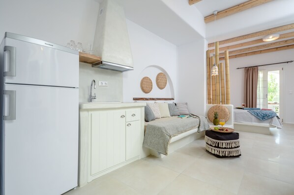 A modern kitchen with a built-in refrigerator, white cabinetry, and a wooden ceiling. - Naxos Nature Suites (Naxos)