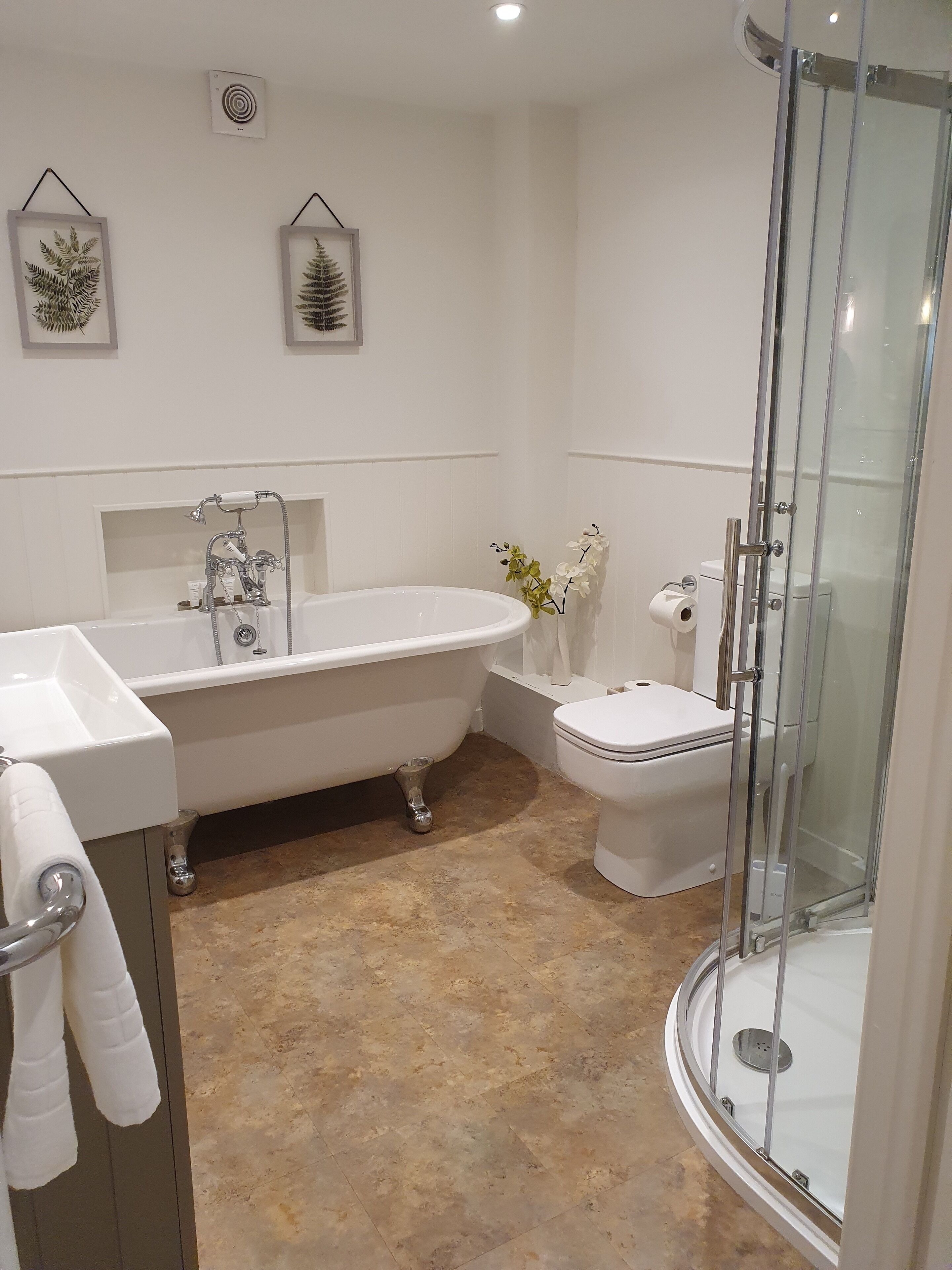 A bathroom with a freestanding bathtub, a toilet, and a glass-enclosed shower.