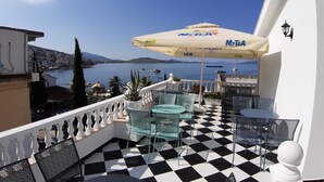Une terrasse dotée d’un sol à carreaux, de sièges extérieurs et offrant une vue sur la mer.