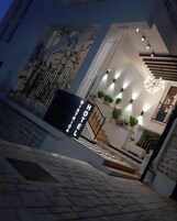 Una entrada de hotel moderna con una escalera, plantas en macetas y un letrero que dice "HOTEL BISTROCA".