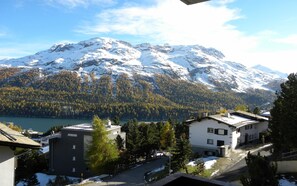 Área residencial com casas, um lago e montanhas cobertas de neve ao fundo.
