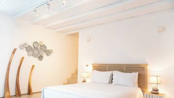 Une chambre moderne avec un grand lit, une tête de lit en bois et un escalier menant à un niveau supérieur.