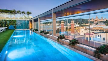 Een seizoensgebonden buitenzwembad, parasols voor strand/zwembad