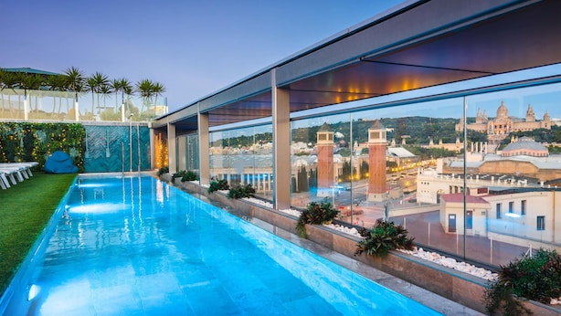 Piscina moderna con vistas despejadas a edificios históricos al fondo.