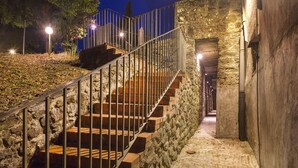 Un escalier en pierre avec des rampes métalliques menant à un niveau supérieur.