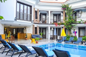 Relax by the pool surrounded by lounge chairs and umbrellas, with stunning views from the hotel's multi-level balconies.