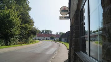 Um edifício com uma placa que diz "Alte Wache" e um anúncio de cerveja acima.