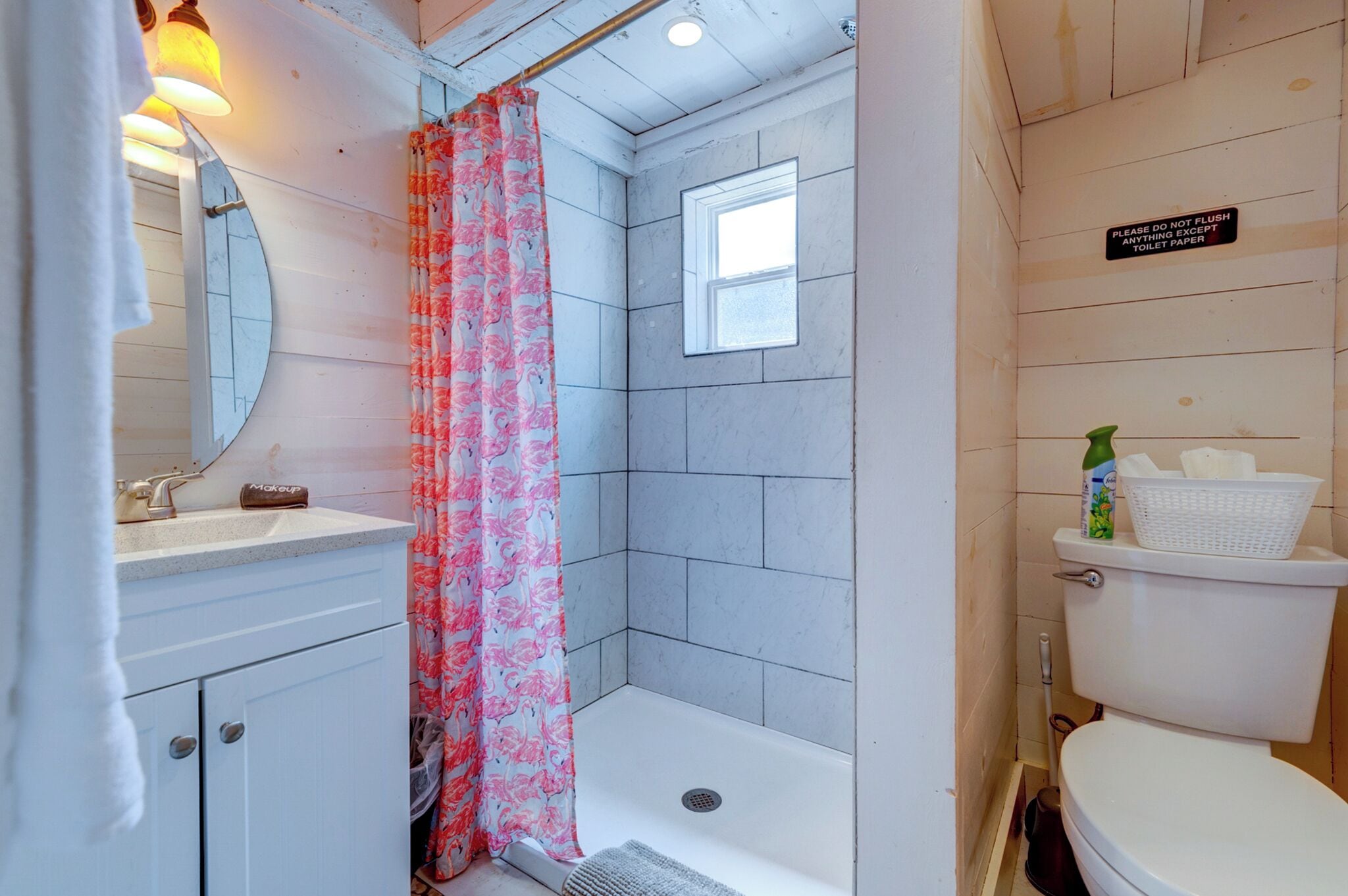 Une salle de bain avec douche, toilettes et lavabo.