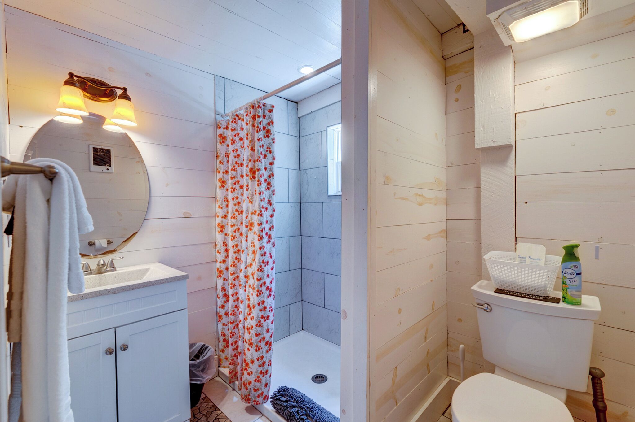 Une salle de bain avec douche, toilettes et lavabo.