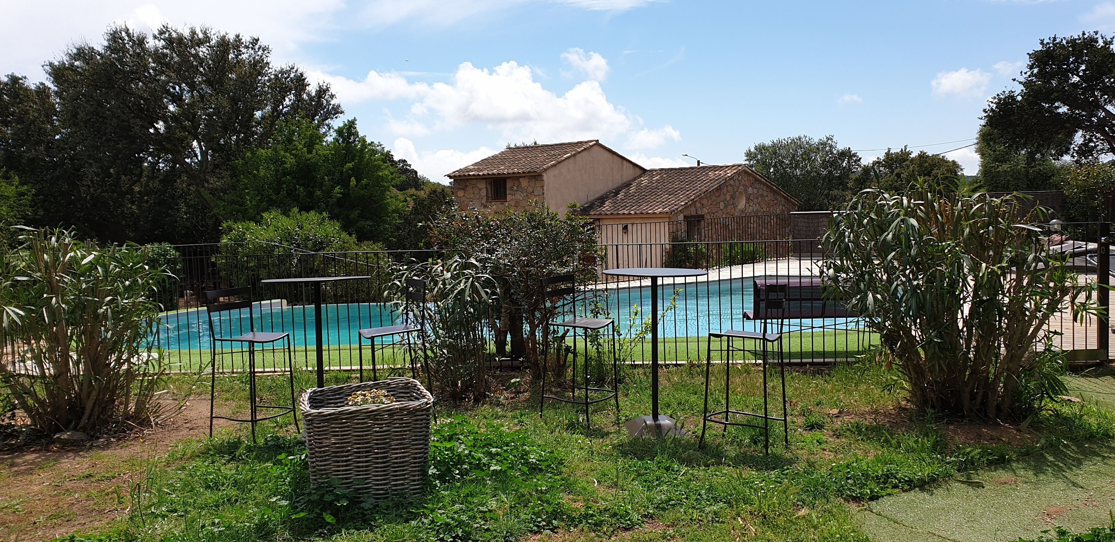 Una piscina al aire libre de temporada, sombrillas, tumbonas