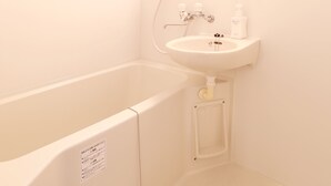 Un baño con bañera, lavamanos y espejo.