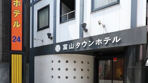 Un edificio moderno con un cartel que dice "富山タウンホテル" (Fujiyama Town Hotel).