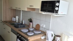 Et køkken med mikroovn, brødrister, elkedel og kaffemaskine.