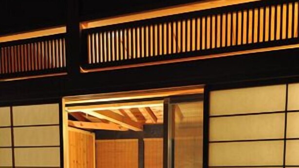 Ein traditioneller japanischer Raum mit Tatami-Boden, einem niedrigen Holztisch und verschiebbaren Shoji-Türen.