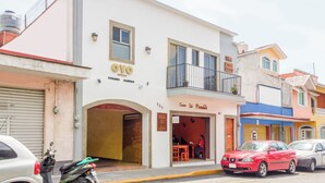 Un hôtel à la façade blanche, doté d’un balcon et d’une enseigne indiquant « Camin La Posada ».