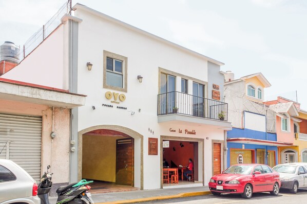 Um hotel com fachada branca, uma varanda e uma placa com a inscrição 'Camin La Posada'.