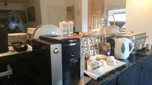 A kitchen area with a coffee machine, a water dispenser, and various kitchen utensils.