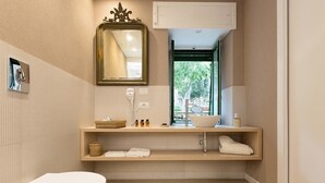 Een moderne badkamer met toilet, wastafel met spiegel, raam en wasbak.