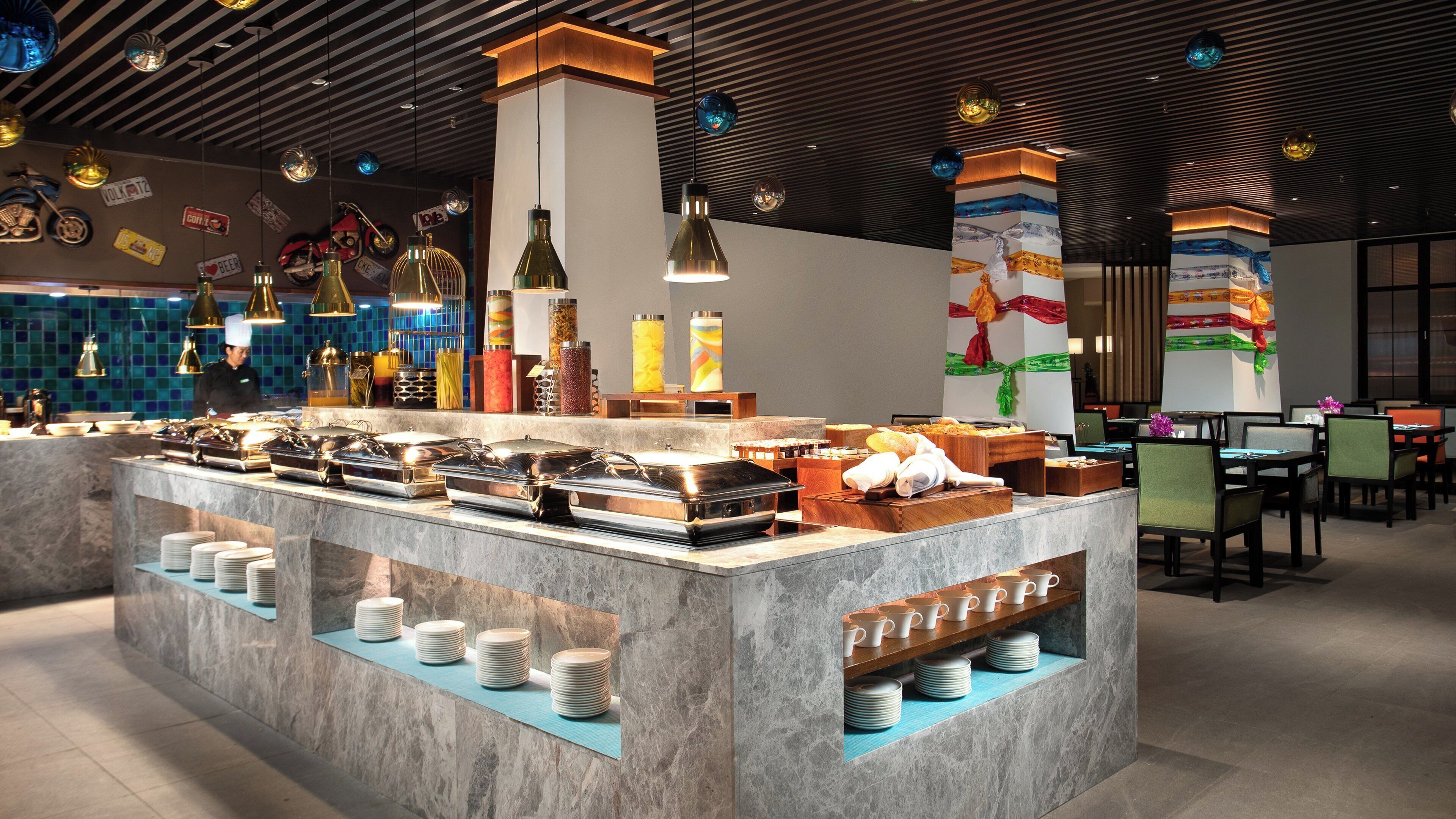 A buffet area with a variety of food containers and a seating area with tables and chairs.