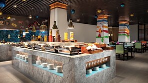A buffet area with a variety of food containers and a seating area with tables and chairs. - Holiday Inn Batang by IHG (Garze)