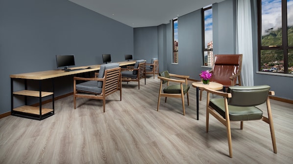 A modern conference room with a long table, multiple chairs, and a large window offering a view of a mountainous landscape. - Holiday Inn Batang by IHG (Garze)