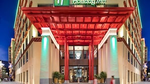 Et Holiday Inn hotel med en rød markise, store vinduer og et skilt på både engelsk og kinesisk.