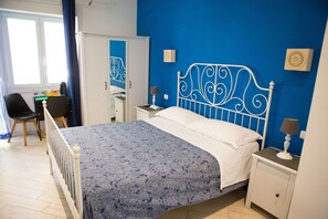 A bedroom with a bed, a nightstand, a desk, and a chair. - Lanzies Guesthouse (Rome)