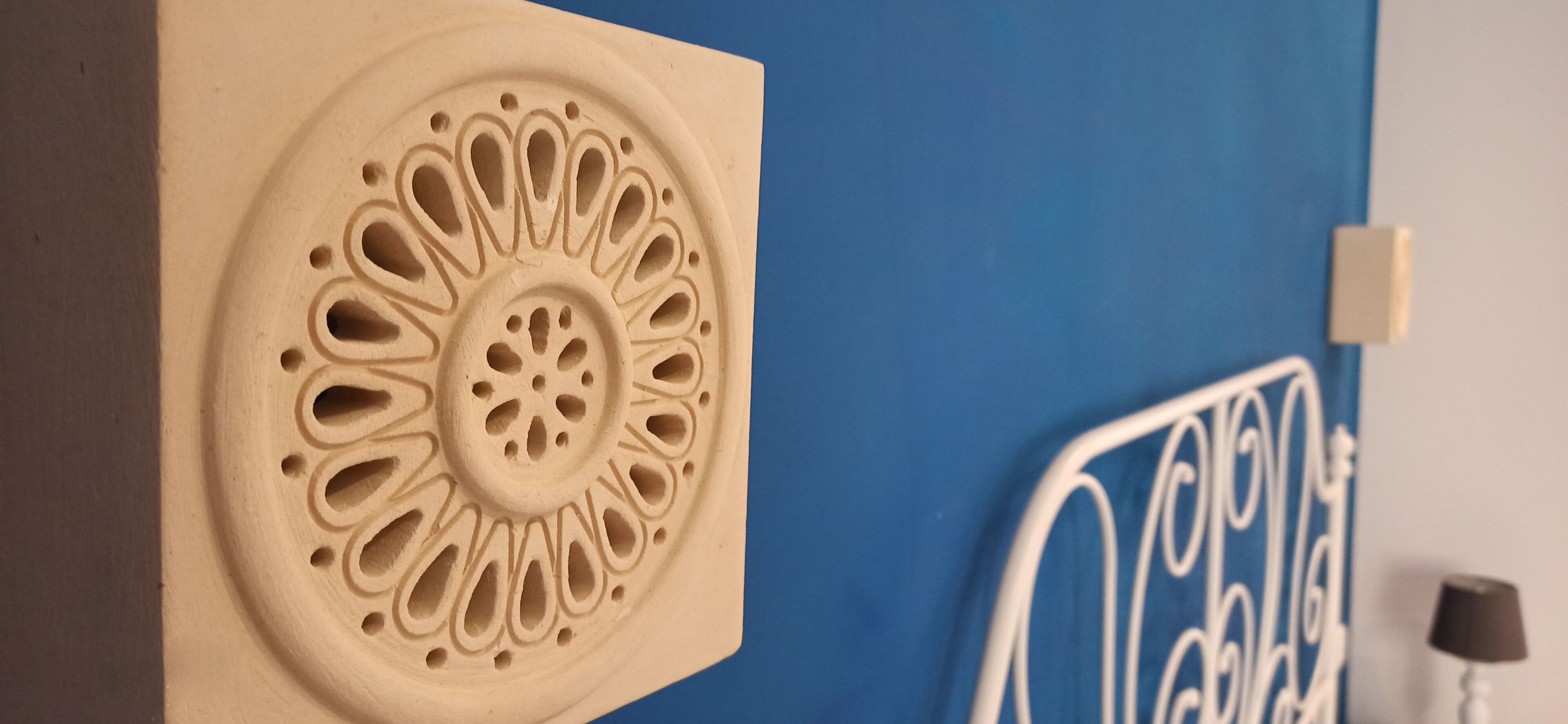Una parete con un pannello decorativo a motivo circolare.