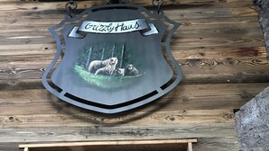 A wooden exterior with a metal sign reading "Grizzly Haus" and a small window. - Grizzly Haus (Ville di Fiemme)