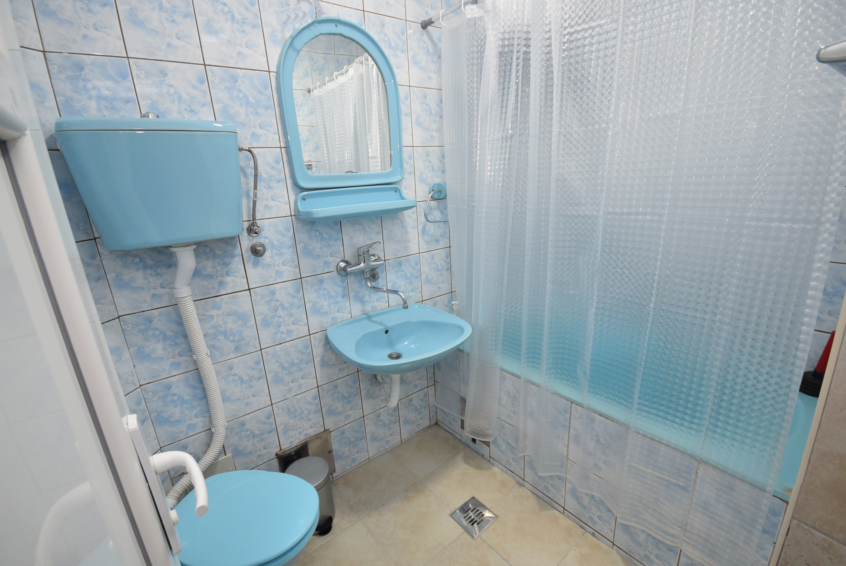 A bathroom with a toilet, sink, and shower.