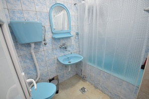Un baño con inodoro, lavabo y ducha.