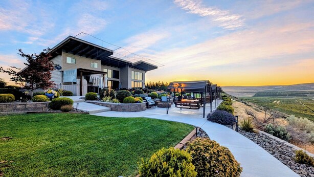 Una casa moderna con un patio, una zona de estar techada y vistas al campo.