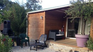 A wooden cabin with a patio area, outdoor seating, and a barbecue grill. - 4/6-person CLIMATIZED WOODEN CHALET, near Algajola beach, countryside & village views (Pigna)