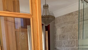 Un dormitorio con una cama, una mesita de noche, una lámpara y un candelabro.