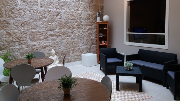 Una sala de estar moderna con una pared de piedra, un ventanal grande y un sofá.