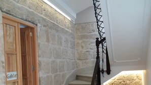 Una escalera con paredes de piedra y una puerta de madera con la inscripción 'Galdar'.
