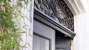 A dark blue door with a brass knocker and a decorative metal crest above it. - Chambres d'Hotes O Anges (Arles)
